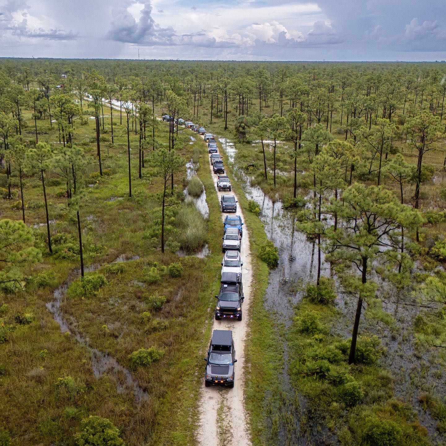 Aerial view of a vehicle on a levee trail through South Florida wetlands